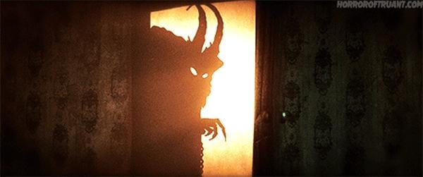 a gif of krampus creeping out from behind a wall