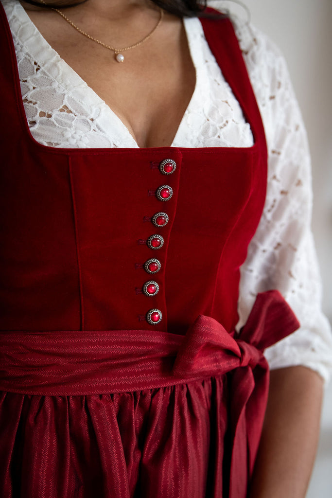 close up image of a dirndl bodice with buttons and a white blouse
